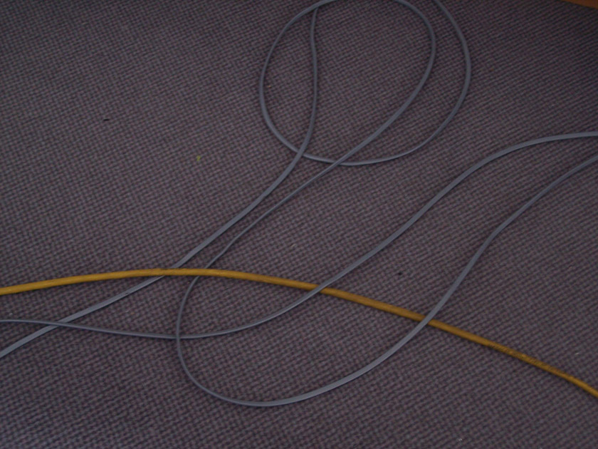 an accidental calligram of cables on carpeted office floor; photo